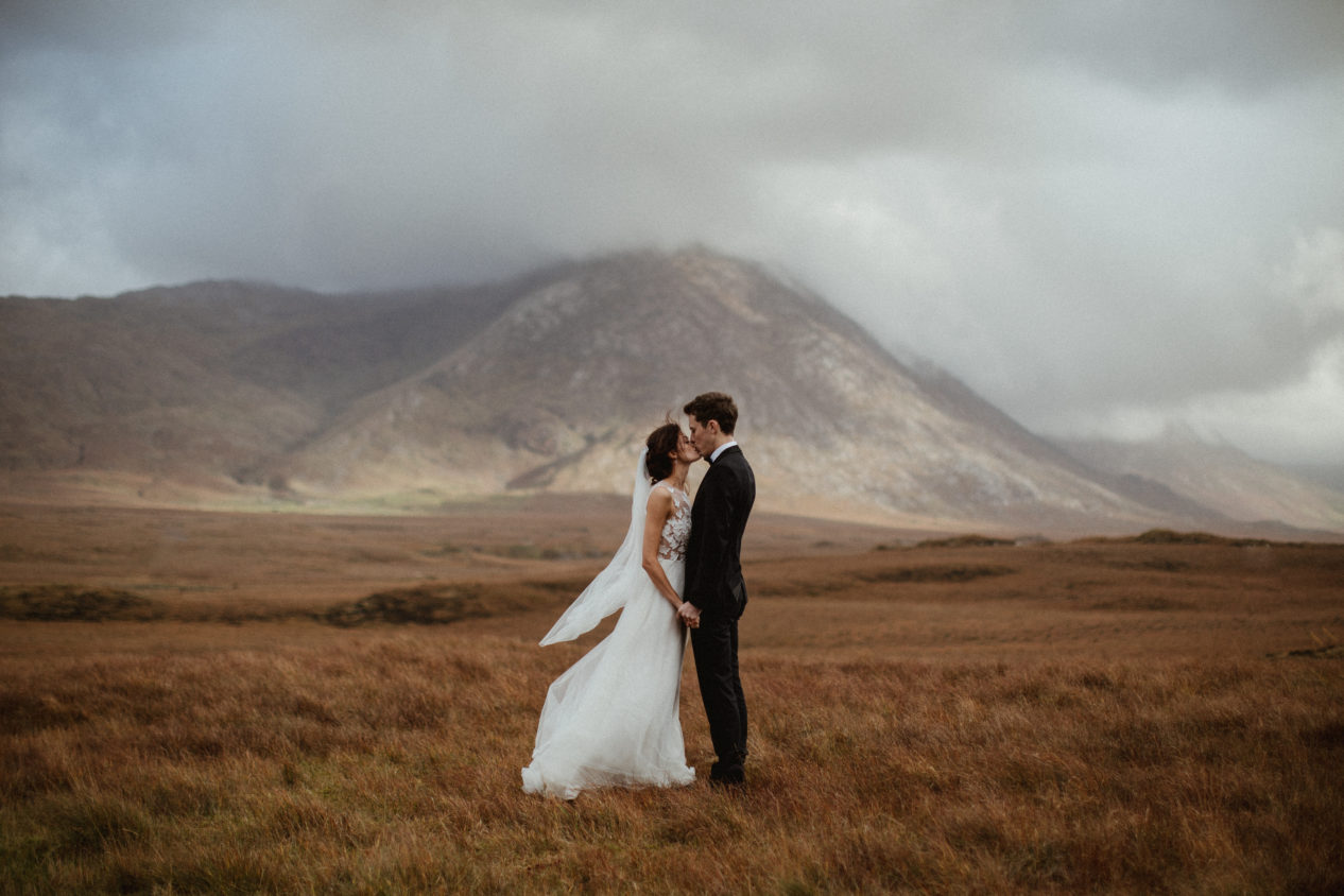 Editorial-style portrait of a couple on their wedding day in the landscape